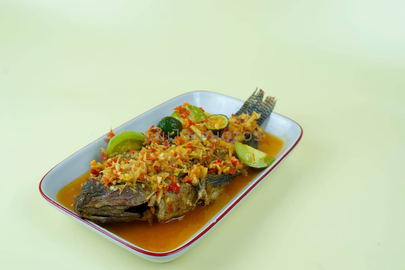 Pecak Ikan Mujair Betawi is a traditional Indonesian dish that originated from Betawi, the native people of Jakarta, Indonesia. Isolated and copy space.