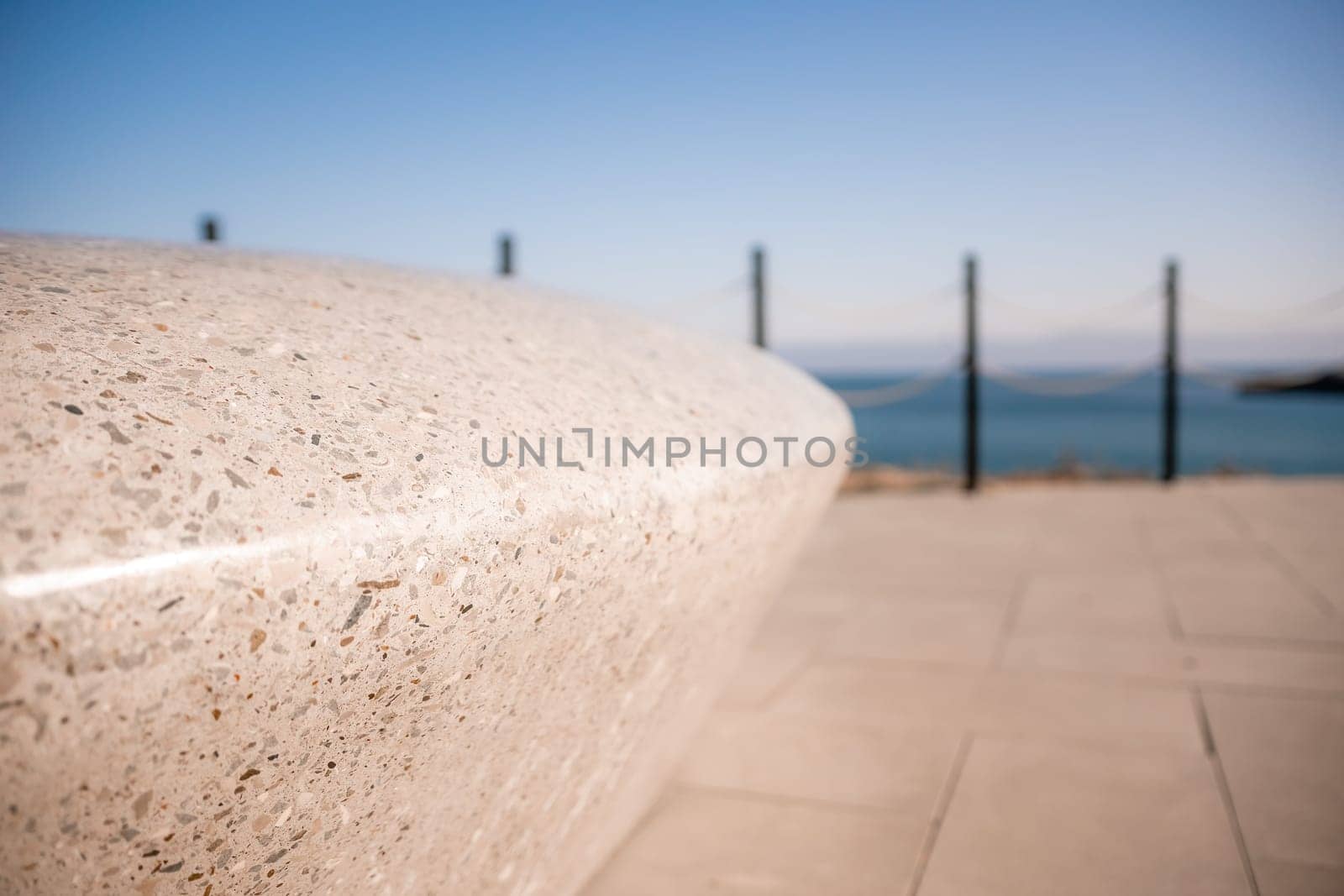 Sea side public park with concreate bench in spring evening.