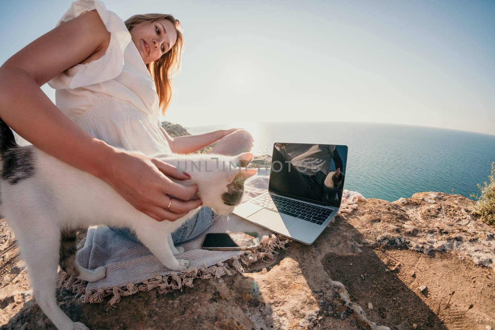 Woman sea laptop. Business woman in yellow hat working on laptop by sea. Close up on hands of pretty lady typing on computer outdoors summer day. Freelance, digital nomad, travel and holidays concept.