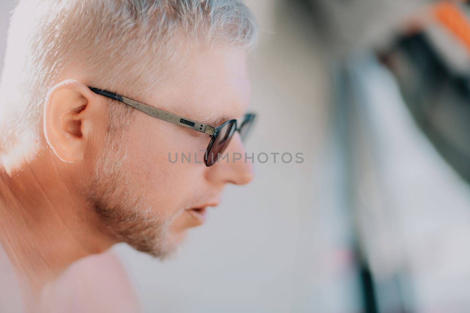 Outdoor portrait of young smiling Caucasian man in white sunglasses on summer ocean coast