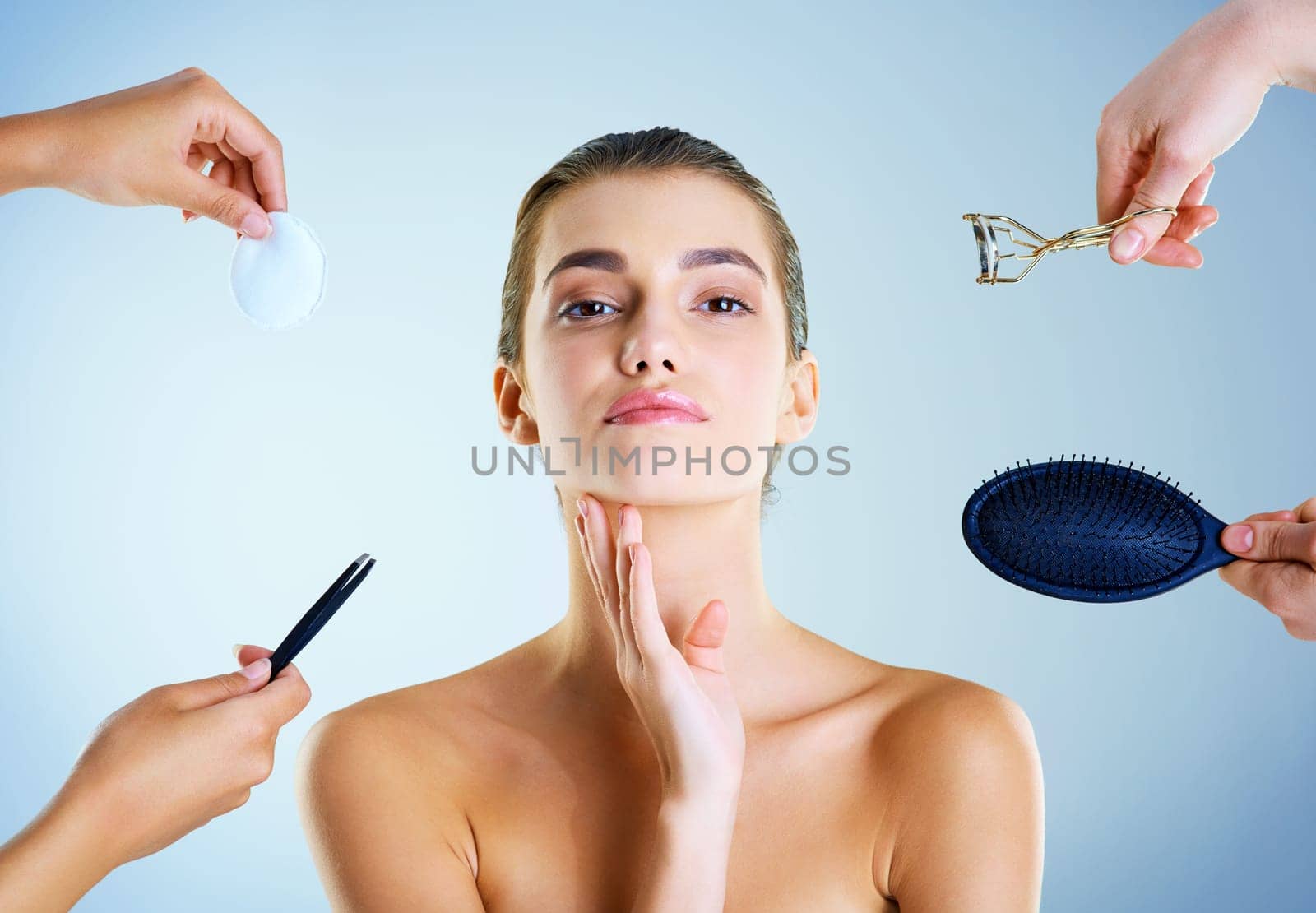 Basic tools for beauty. Studio portrait of a beautiful young woman with an assortment of beauty tools around her against a blue background