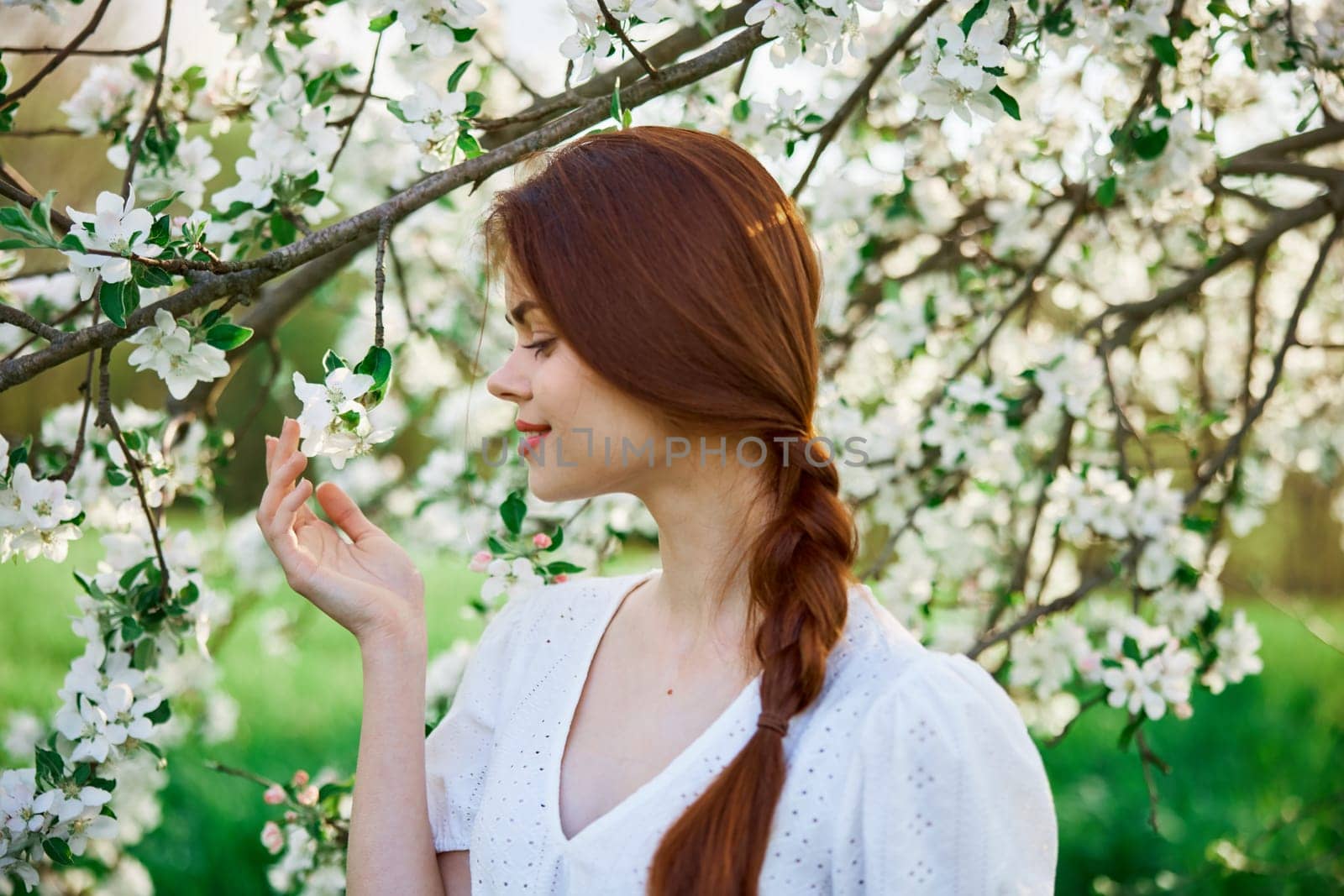 woman with flowers. gorgeous model in the spring garden. the girl near the tree in the spring. the concept of spring. young orchard by Vichizh