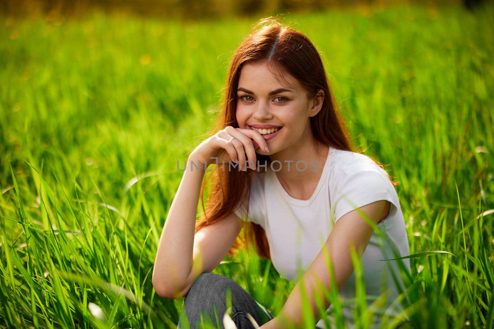 portrait of a happy woman in a white t-shirt with her hands folded in front of her face. High quality photo