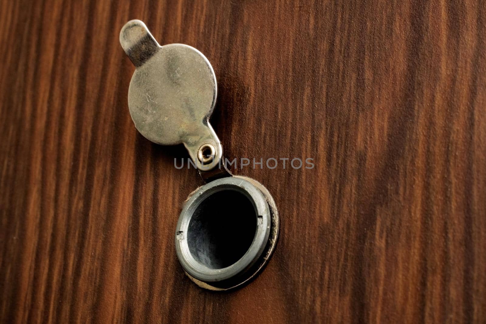 Peephole at the door with a wooden texture close up