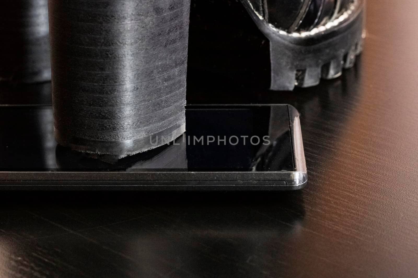 Screen telephone with black heel shoes close up