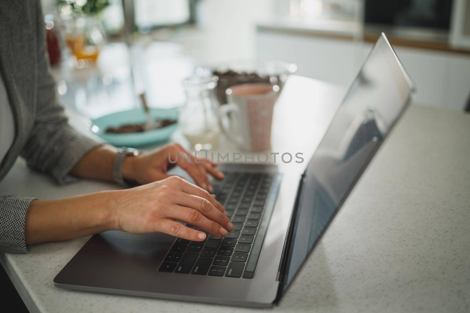 Cropped shot of an unrecognizable businesswoman sitting alone and typing on her laptop during the day at home.
