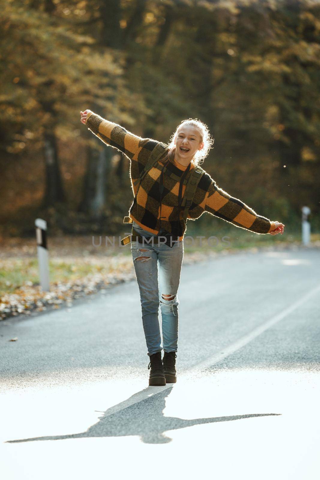 Shot of a teen girl having fun during walk through the forest in autumn.