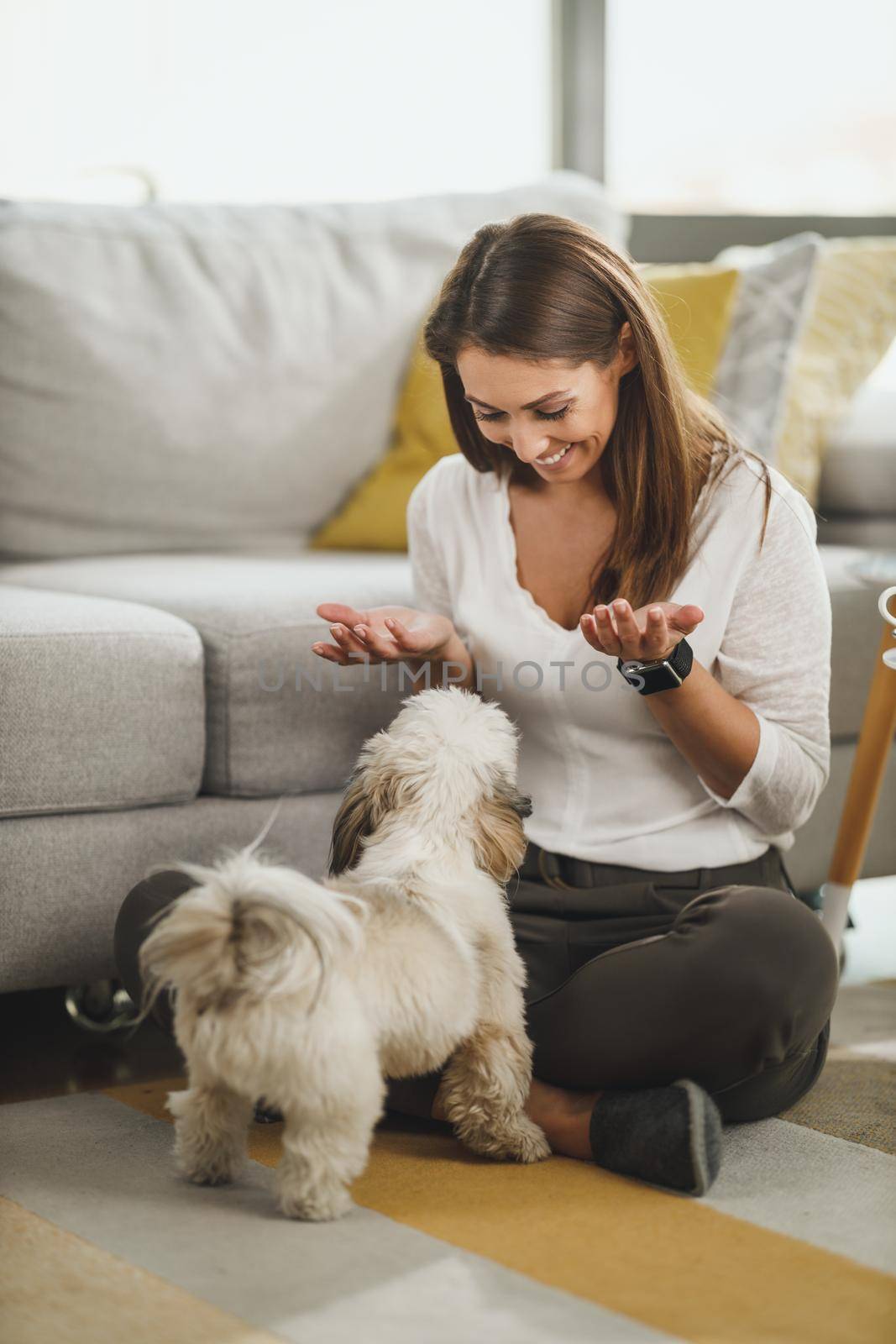 Shot of a cute young woman relaxing with pet dog in her living room at the home.