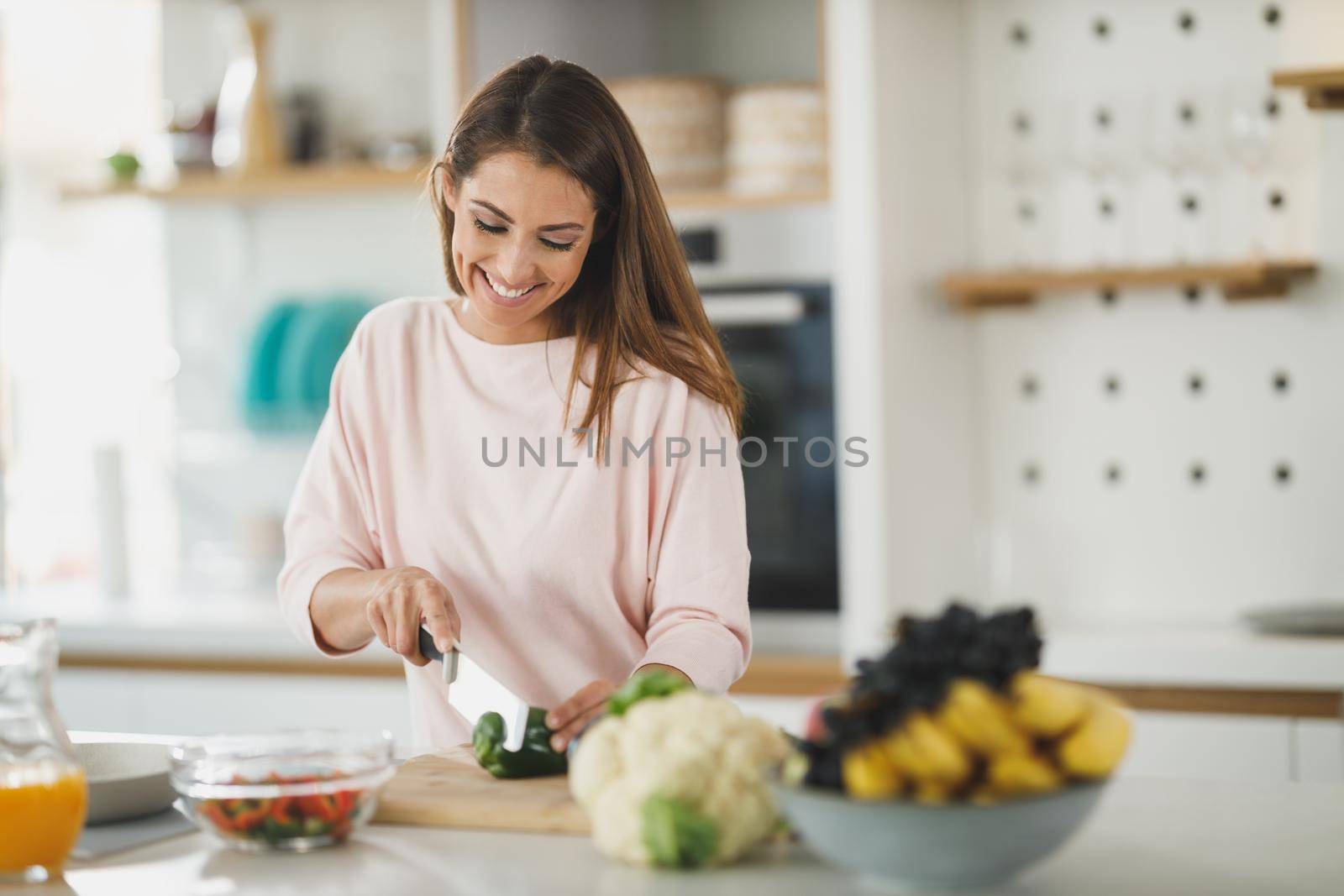 Shot of a young woman chopping vegetables and preparing a healthy meal in her kitchen.
