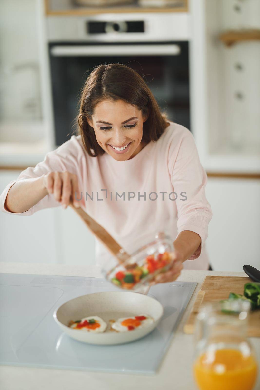 Shot of a young woman preparing a healthy meal on the stove in her kitchen.