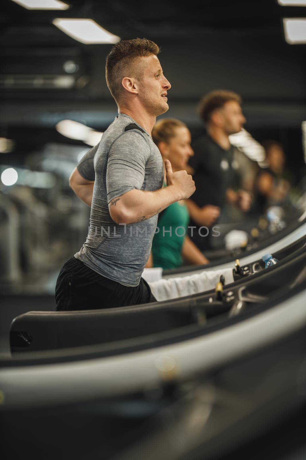 Shot of a young man jogging on a treadmill at the gym.