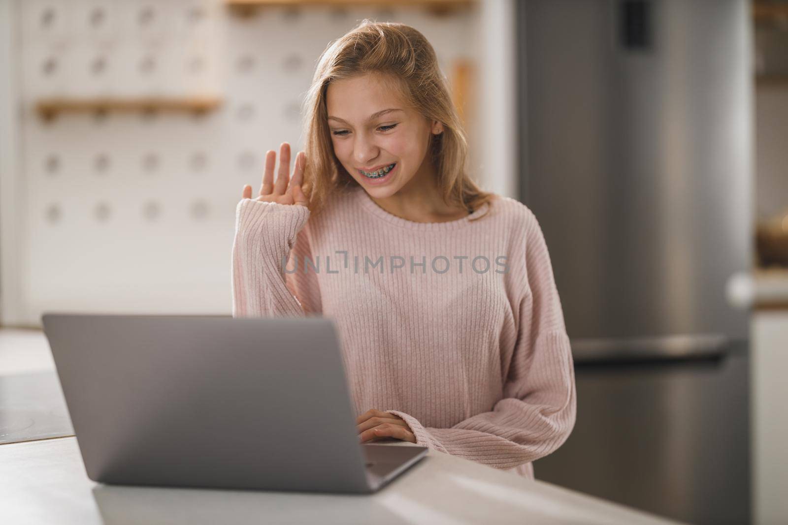 Shot of a cute teenage girl making a video call on laptop while having leisure time at her home during corona virus pandemic.