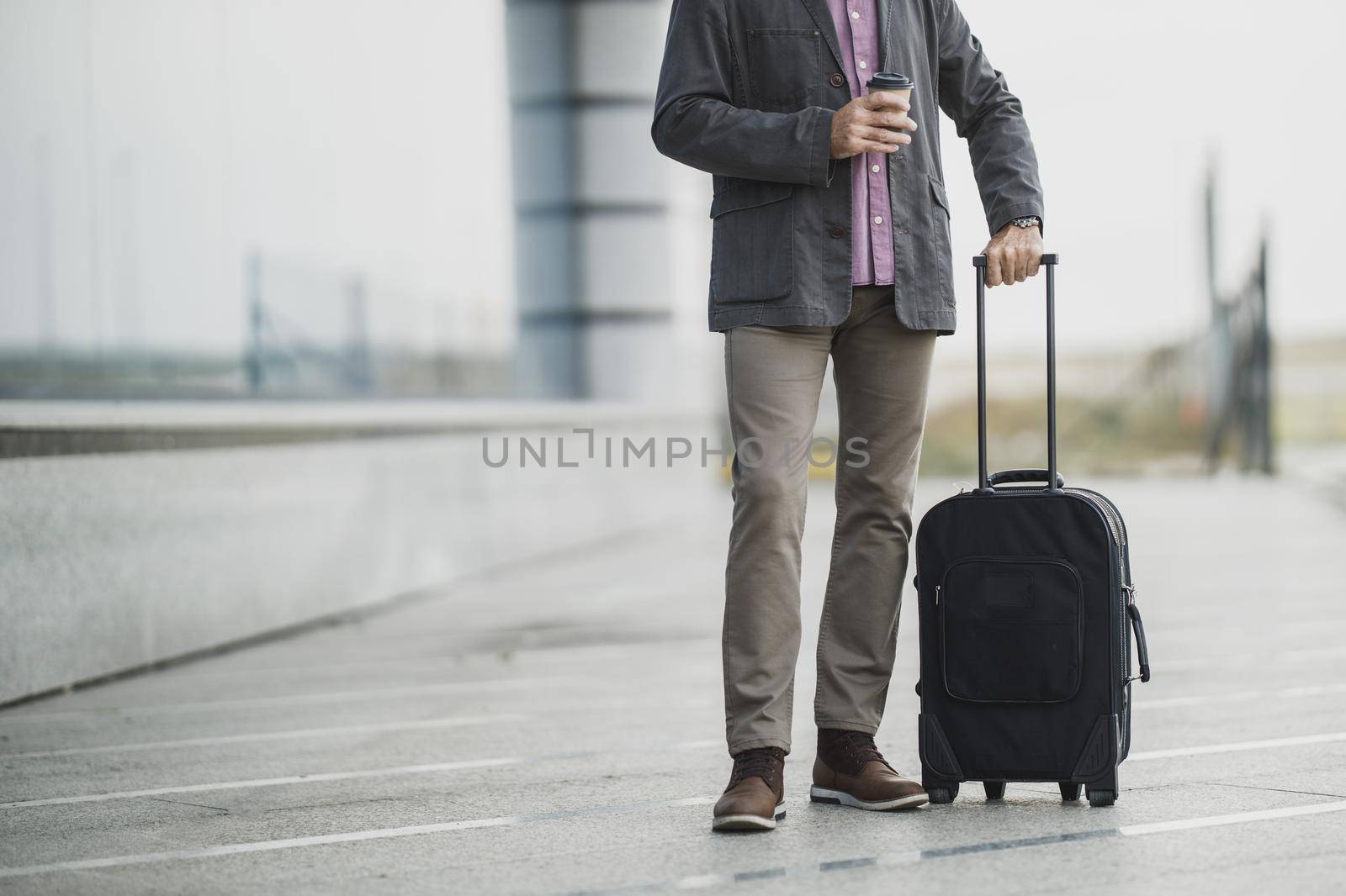 Shot of an unrecognisable senior businessman walking with his luggage outside of the airport.
