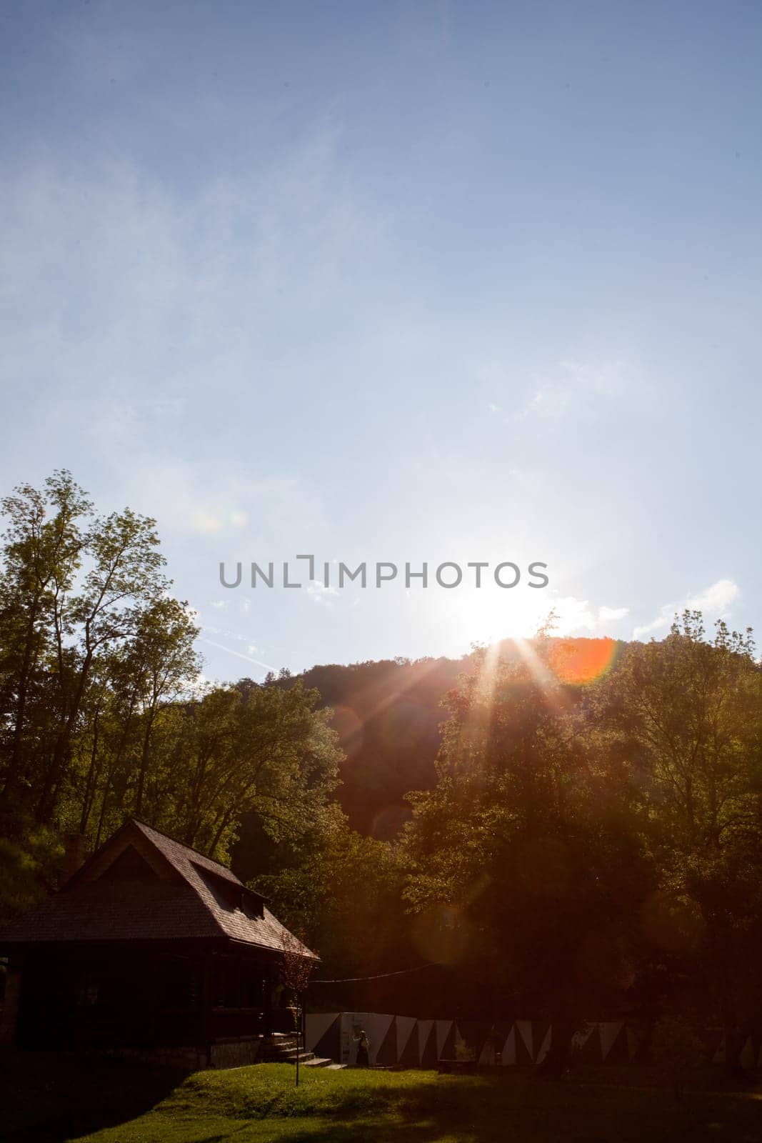 Sunset in the mountains over a rustic house. Travel and sunlight
