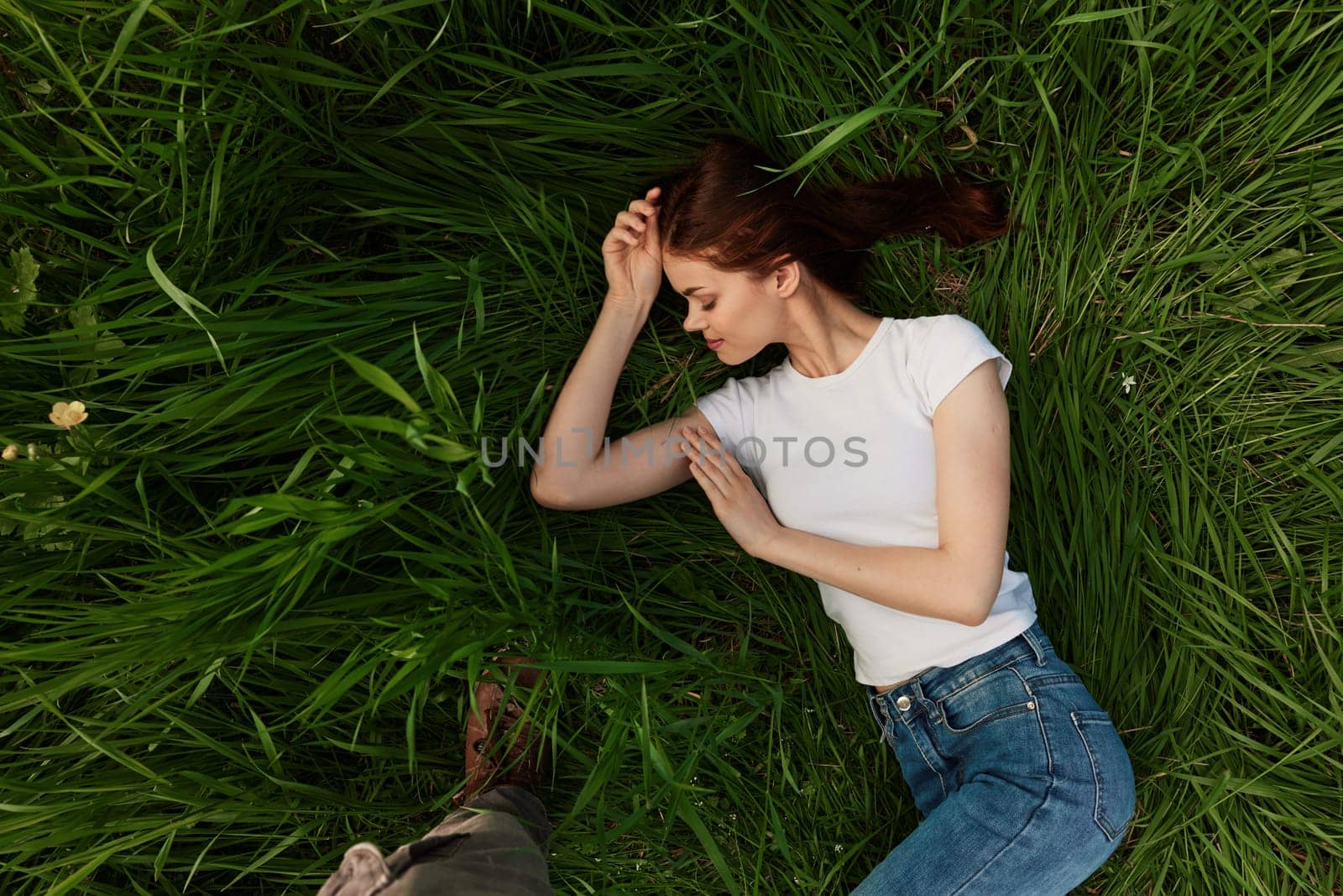 top view of a joyful woman lying in the grass. High quality photo