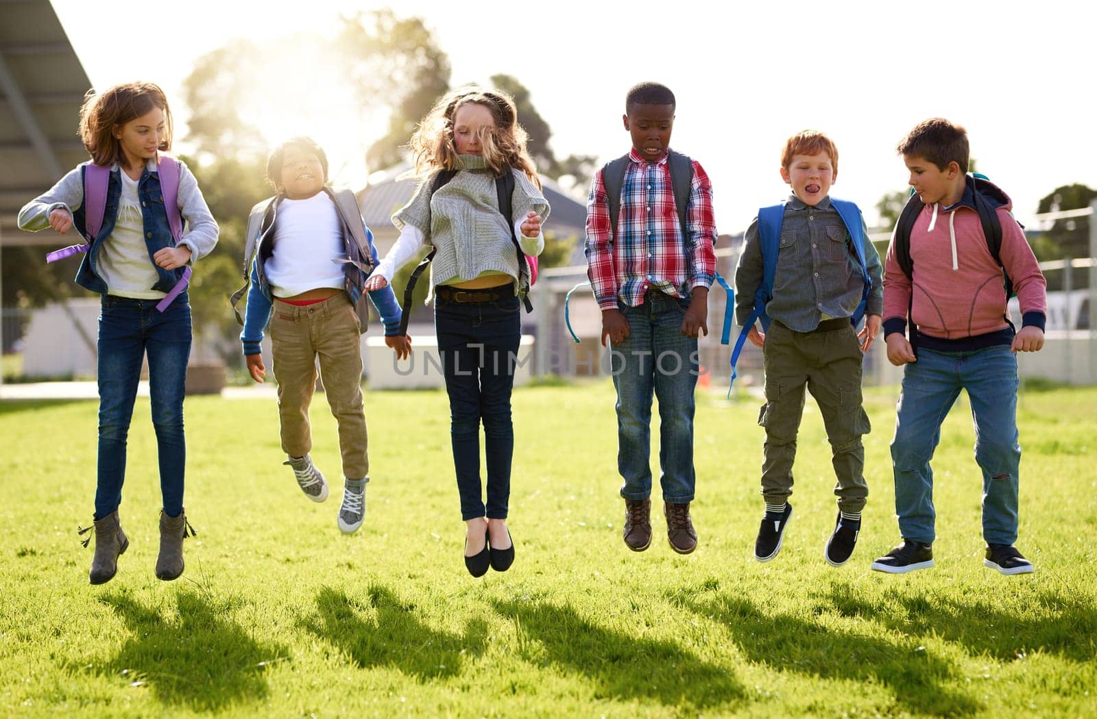 Doing what kids do best, jumping for joy. young kids playing together outdoors. by YuriArcurs