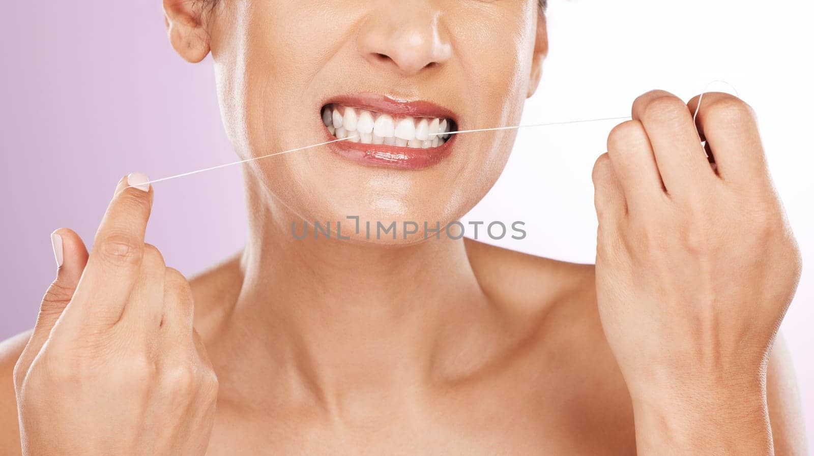 Face, woman and flossing teeth for cleaning, hygiene or tooth care in studio isolated on a purple background. Oral health, fresh breath or mature female model with dental floss or thread for wellness by YuriArcurs