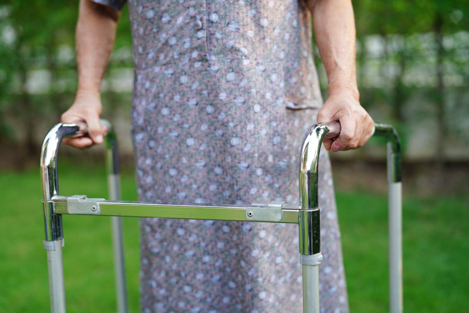Asian elderly woman disability patient walk with walker in park, medical concept. by sweettomato