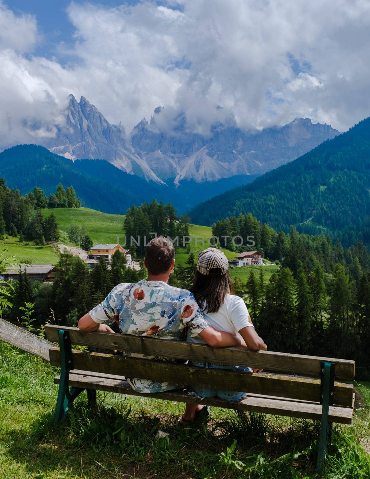 Couple viewing the landscape of Santa Maddalena Village in Dolomites Italy, Santa Magdalena village magical Dolomites mountains, Val di Funes valley, Trentino Alto Adige region, South Tyrol, Italy,