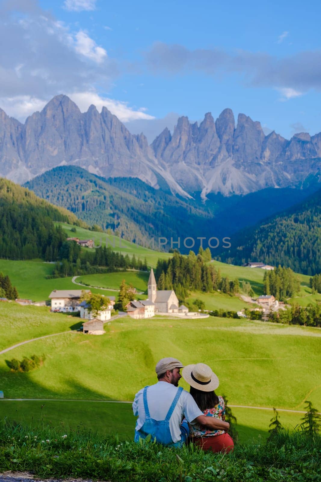 Couple viewing the landscape of Santa Maddalena Village in Dolomites Italy, Santa Magdalena village magical Dolomites mountains, Val di Funes valley, Trentino Alto Adige region, South Tyrol, Italy,