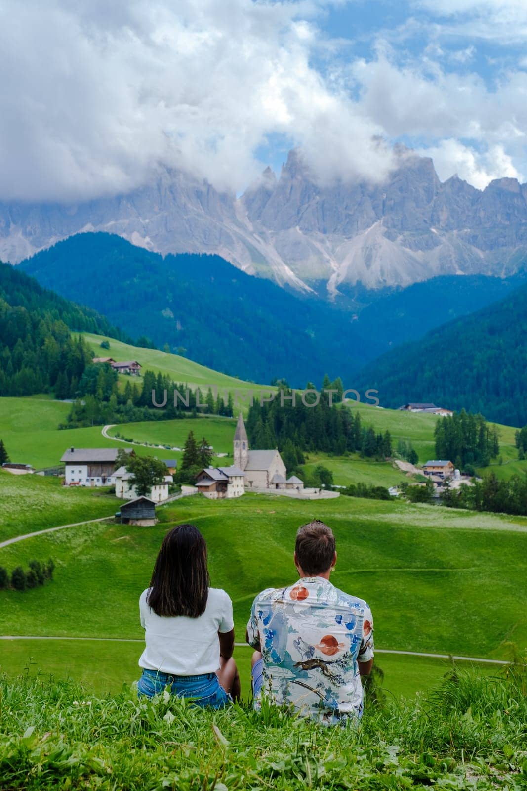 Couple viewing the landscape of Santa Maddalena Village in Dolomites Italy by fokkebok