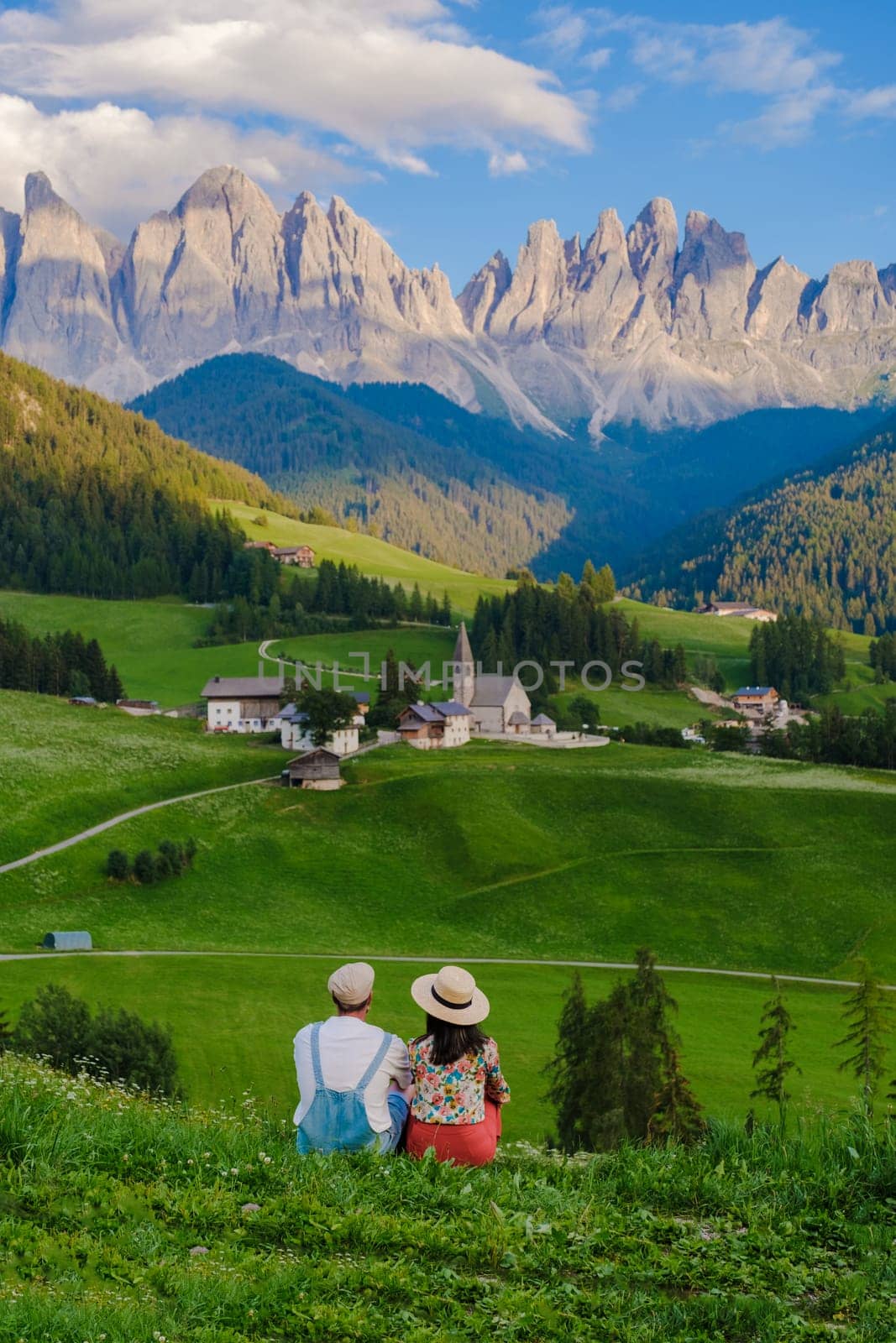 Couple viewing the landscape of Santa Maddalena Village Val di Funes, South Tyrol, Italy Dolomites, men and women visit Dolomites mountains, Val di Funes valley, Trentino Alto Adige, South Tyrol, Italy,