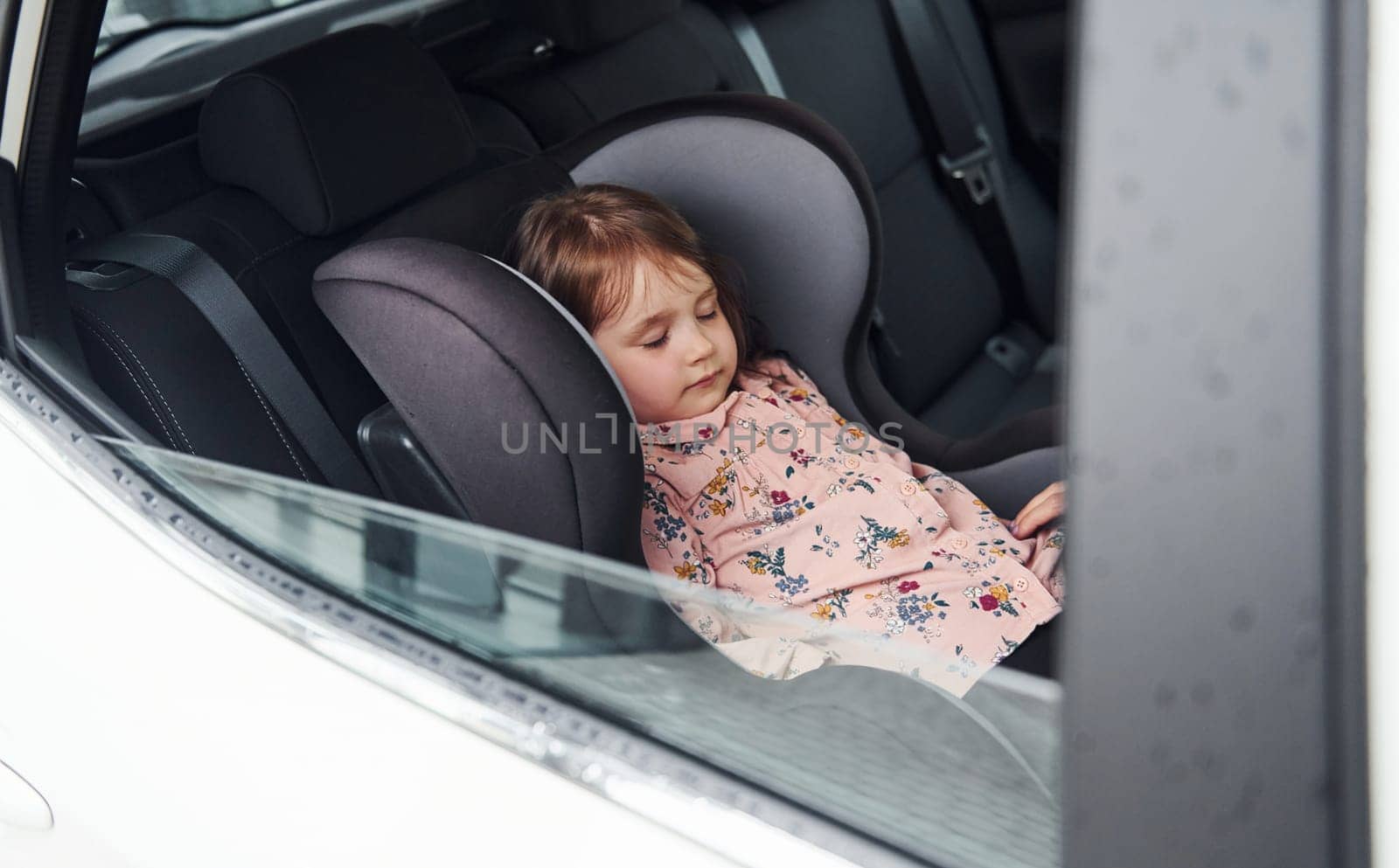 Cute little girl sleeping inside of the car. Conception of traveling and vaccation.