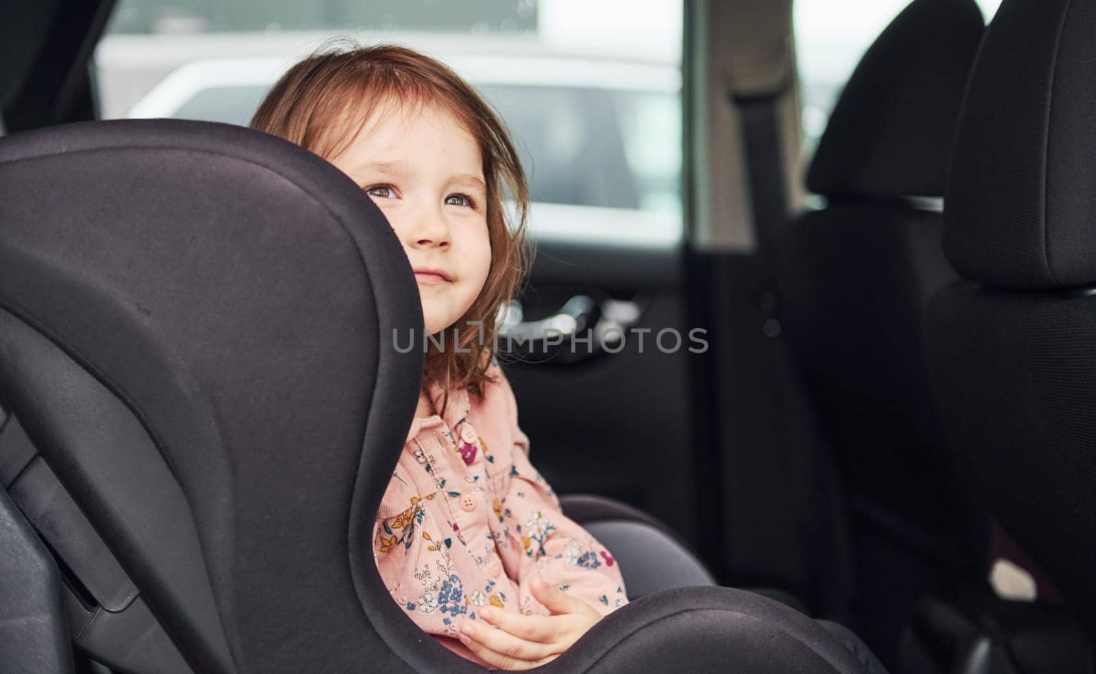 Cute little girl looks through window car. Conception of traveling and vaccation.