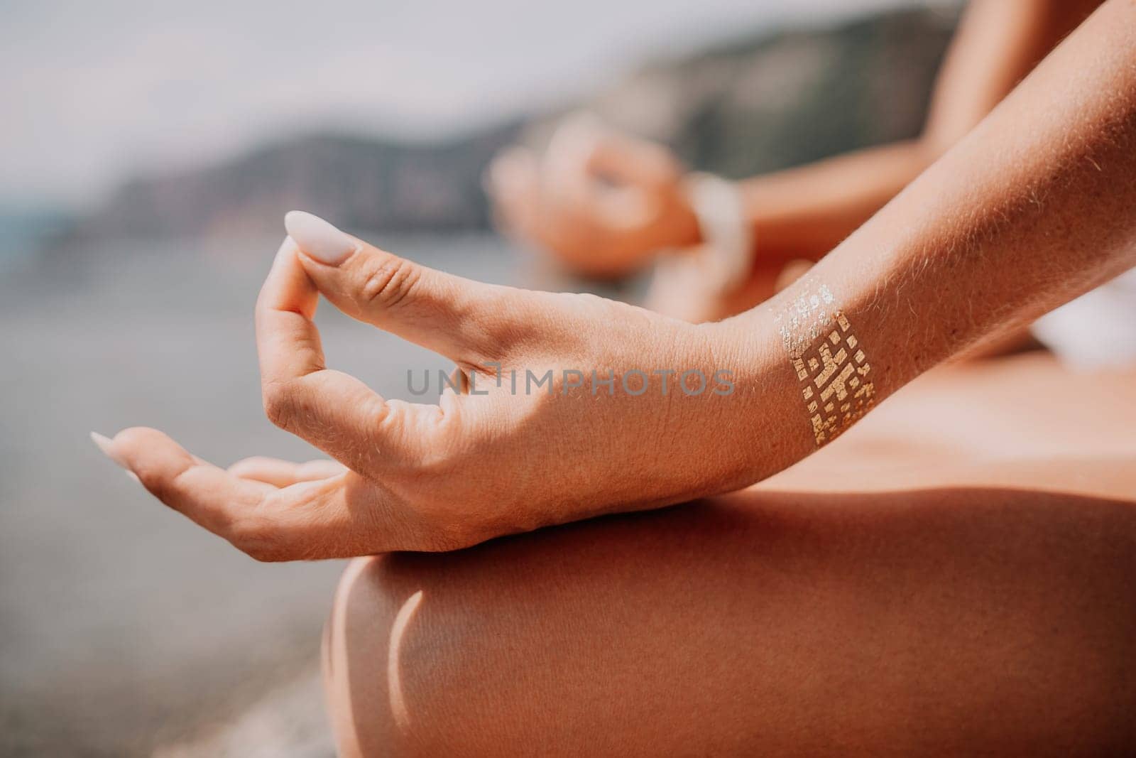 Woman sea yoga. Back view of free calm happy satisfied woman with long hair standing on top rock with yoga position against of sky by the sea. Healthy lifestyle outdoors in nature, fitness concept.