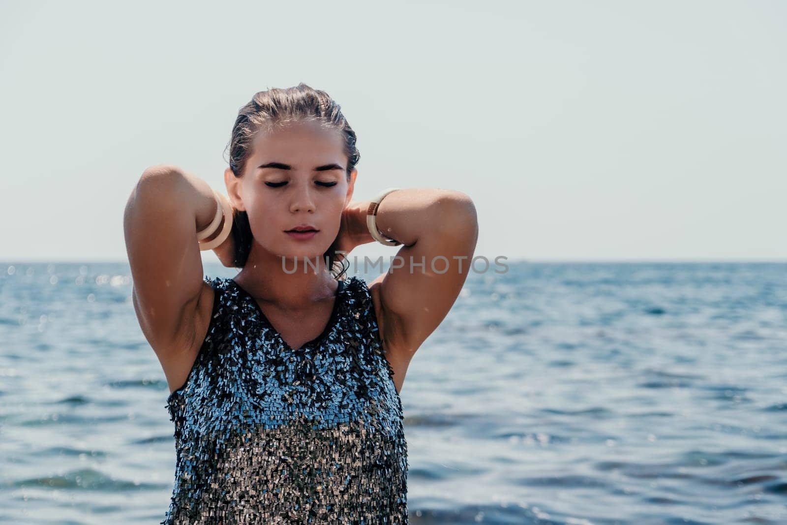 Woman travel sea. Young Happy woman in a long red dress posing on a beach near the sea on background of volcanic rocks, like in Iceland, sharing travel adventure journey