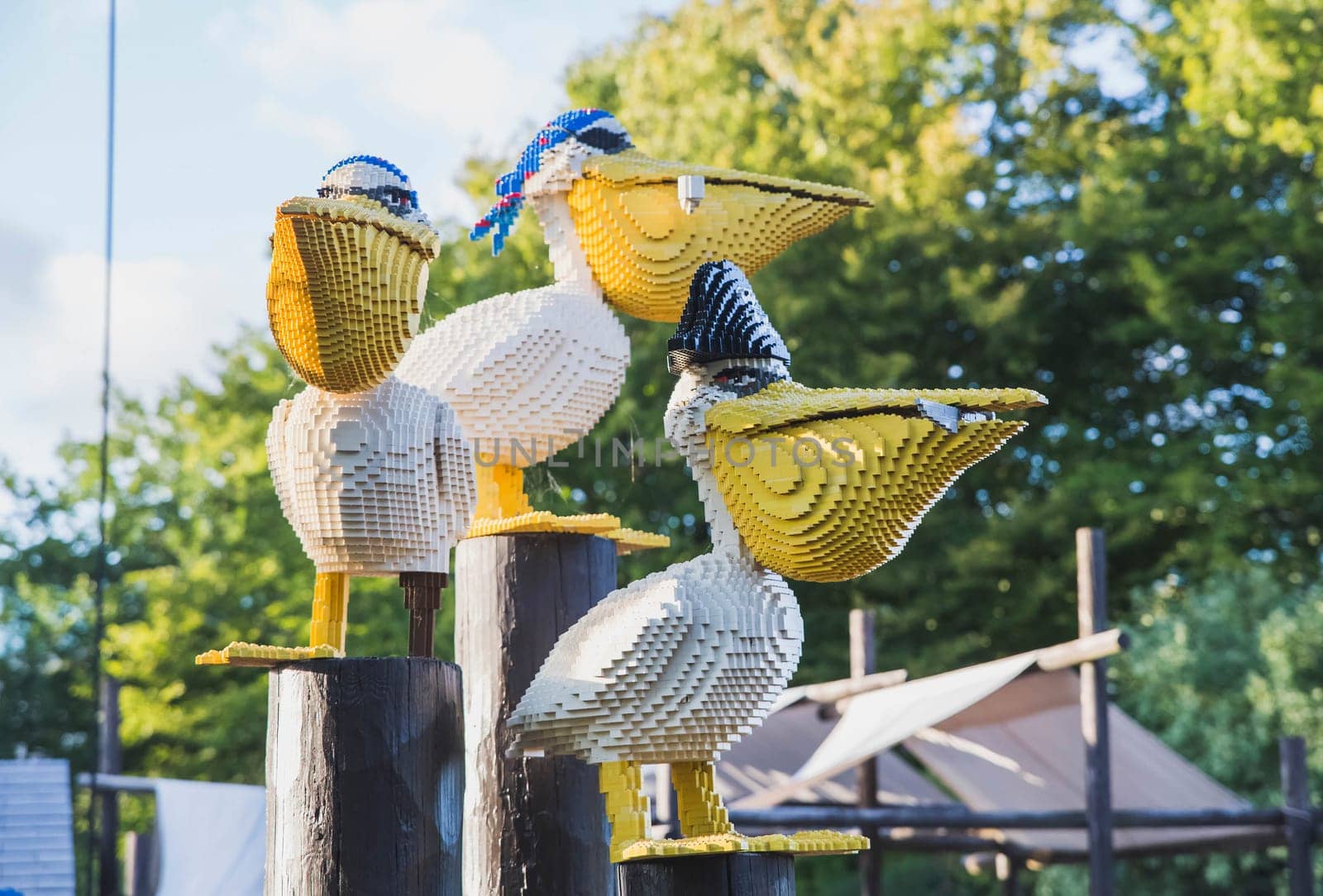 Billund, Denmark, July 2018: pelicans made of constructor sit on stumps.