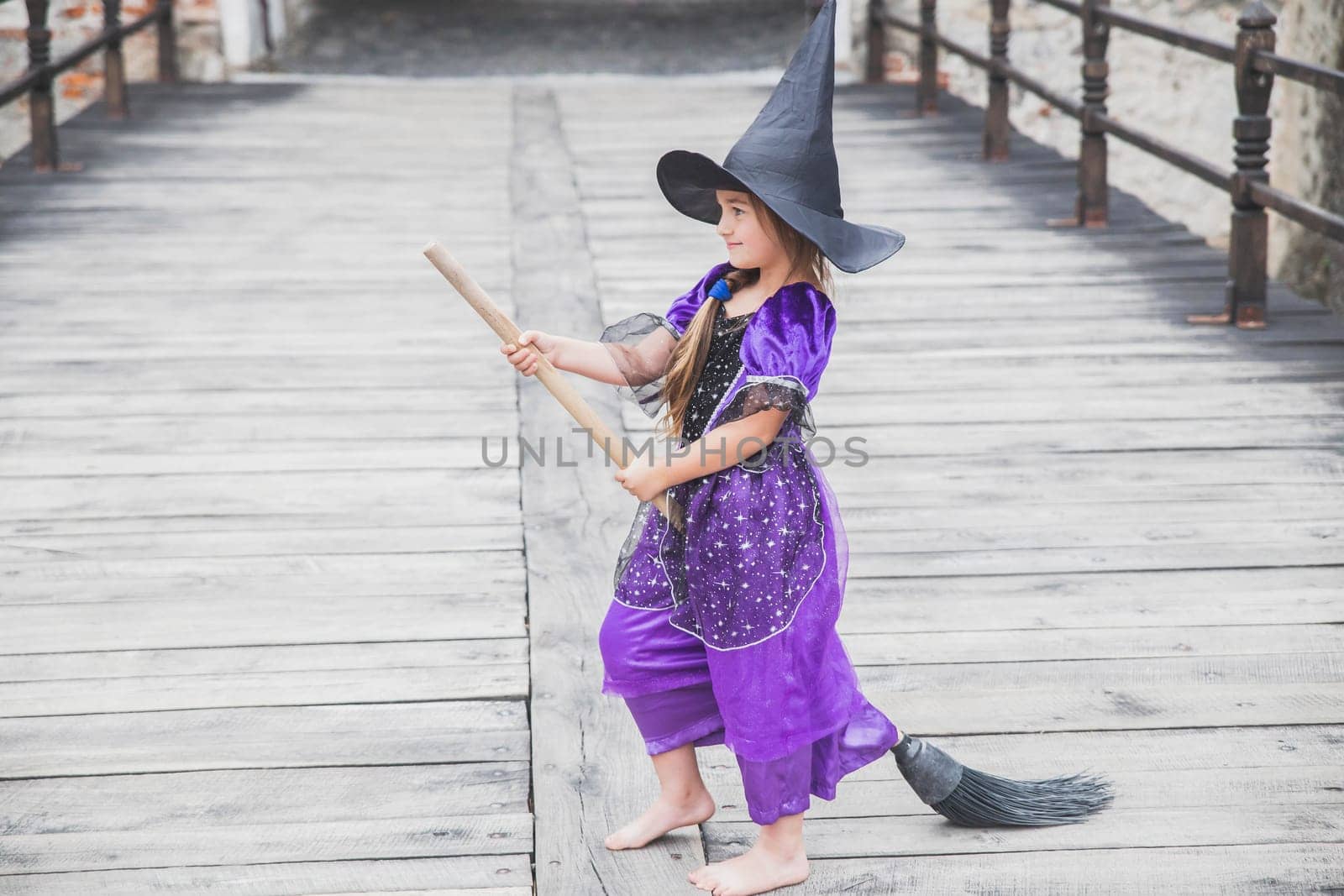 young sorceress is about to take off on a broomstick in the castle.