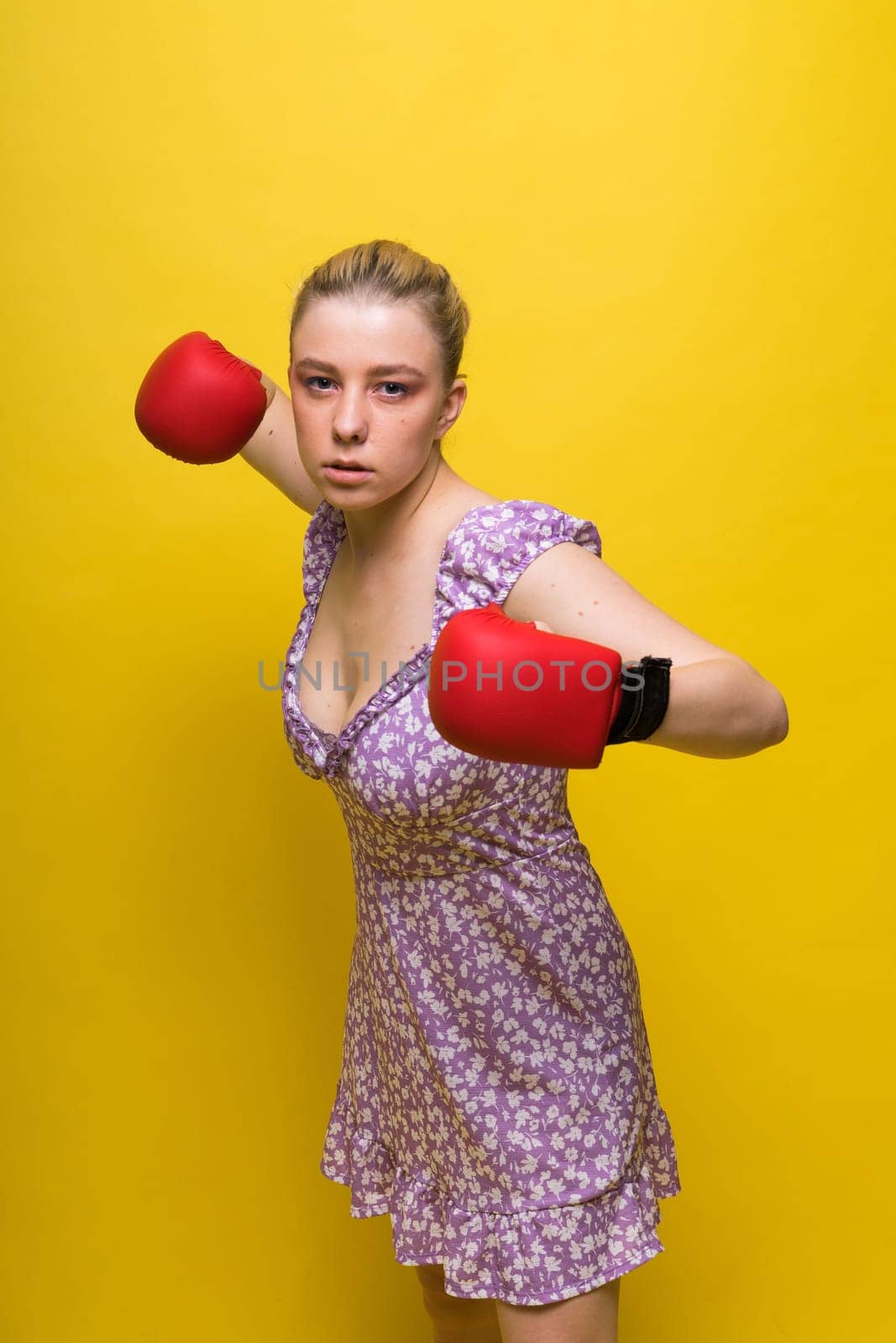 Image of a seductive young woman boxer posing isolated on yellow red background in boxing gloves. by Zelenin