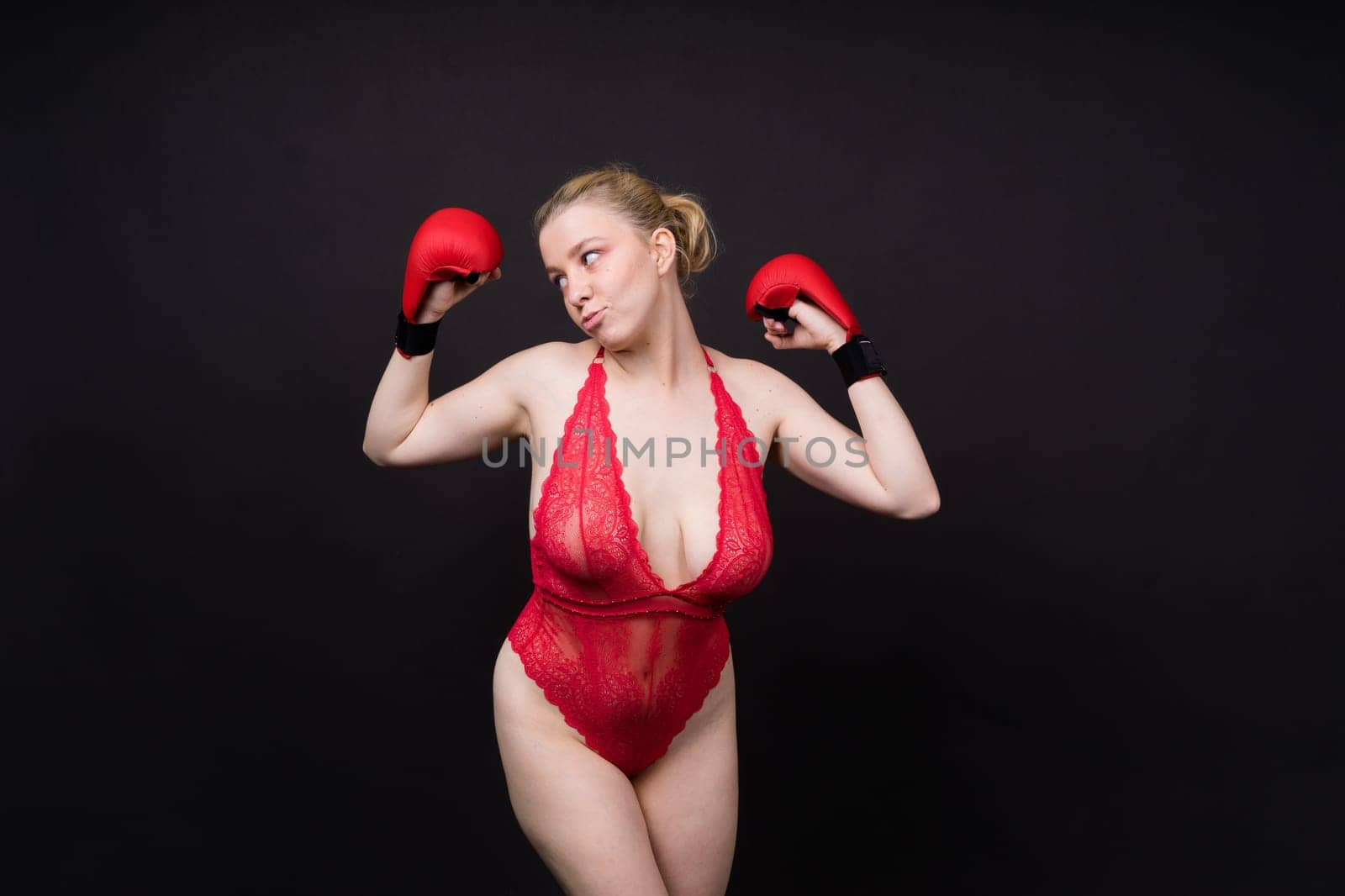 Image of seductive young woman boxer posing isolated on yellow red background in boxing gloves.