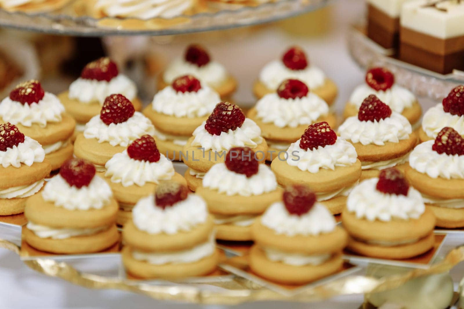 Wedding candy bar table. Cakes with cream and berries and other sweets. High quality photo.