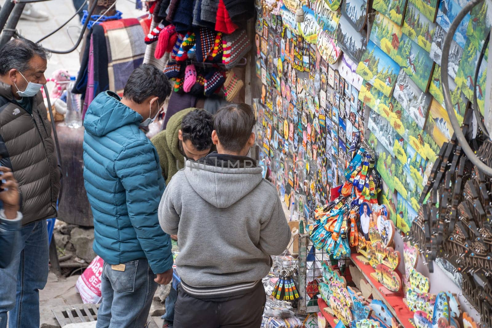Manali, HImachal Pradesh, India - circa 2023 : Aerial shot of group of people buying magnets as souvenir at mall road Manali