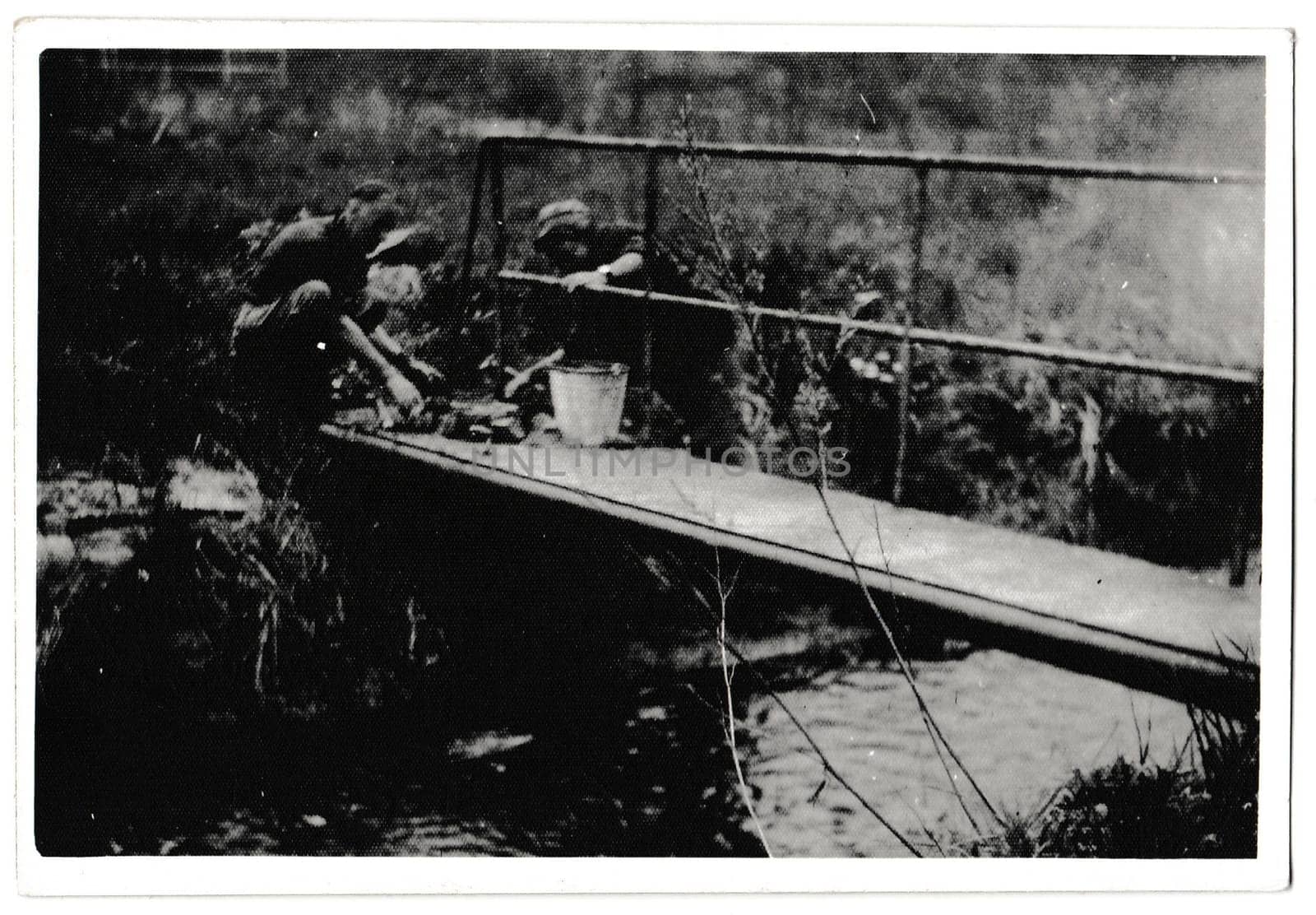 THE CZECHOSLOVAK SOCIALIST REPUBLIC - MAY 17, 1985: Retro photo shows volunteers build footbridge in the forest. Black and white vintage photography