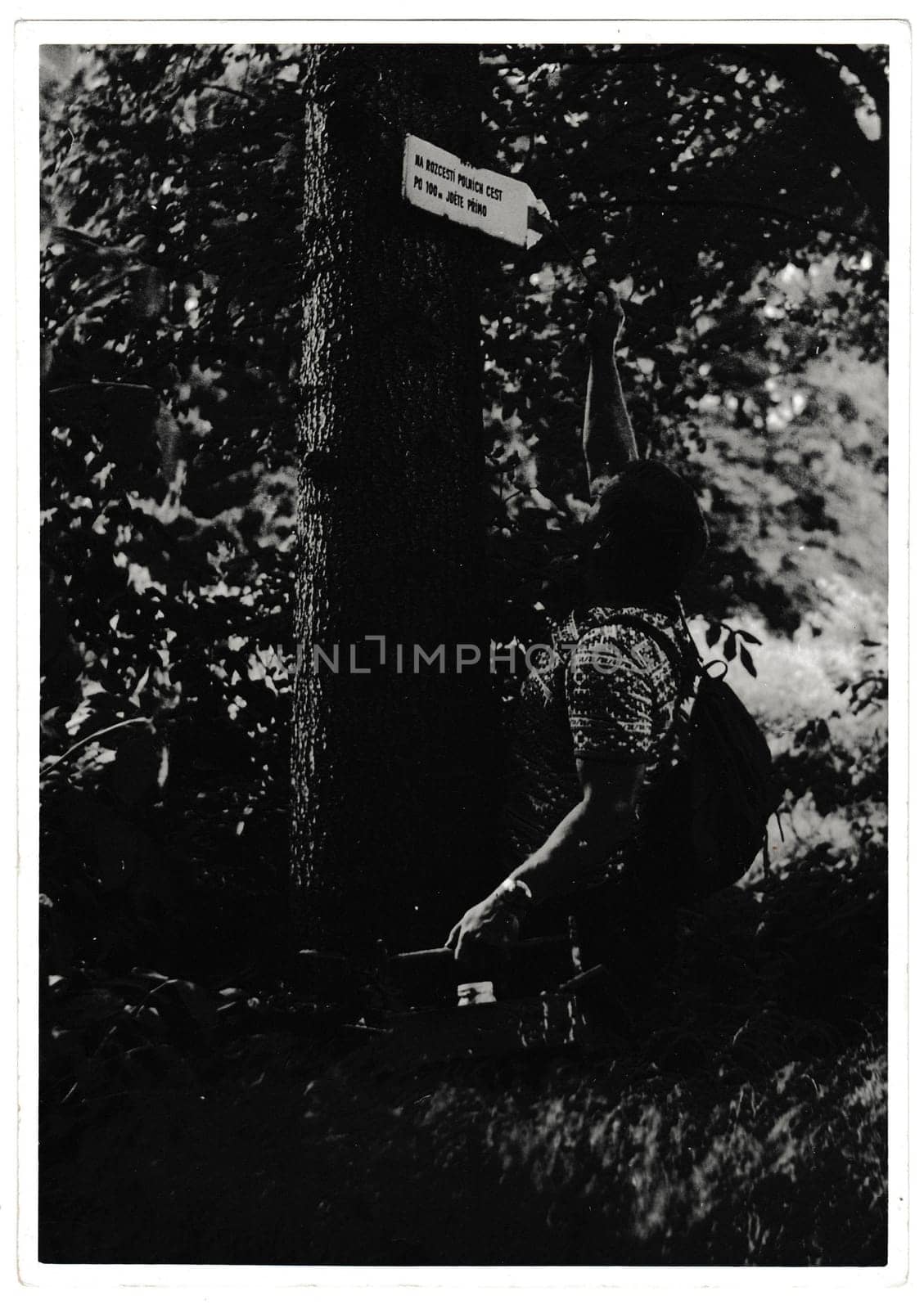 Retro photo shows volunteer renovate a touristic sign. Black and white vintage photography by roman_nerud