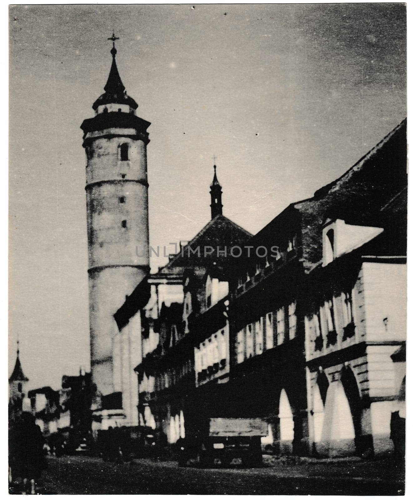 DOMAZLICE, THE CZECHOSLOVAK SOCIALIST REPUBLIC - CIRCA 1960s: Retro photo shows landmark of Domazlice - the tower of the archdean church in the square. It is 56 metres high and its deviation from the axis is 60 cm. Black and white vintage photography.