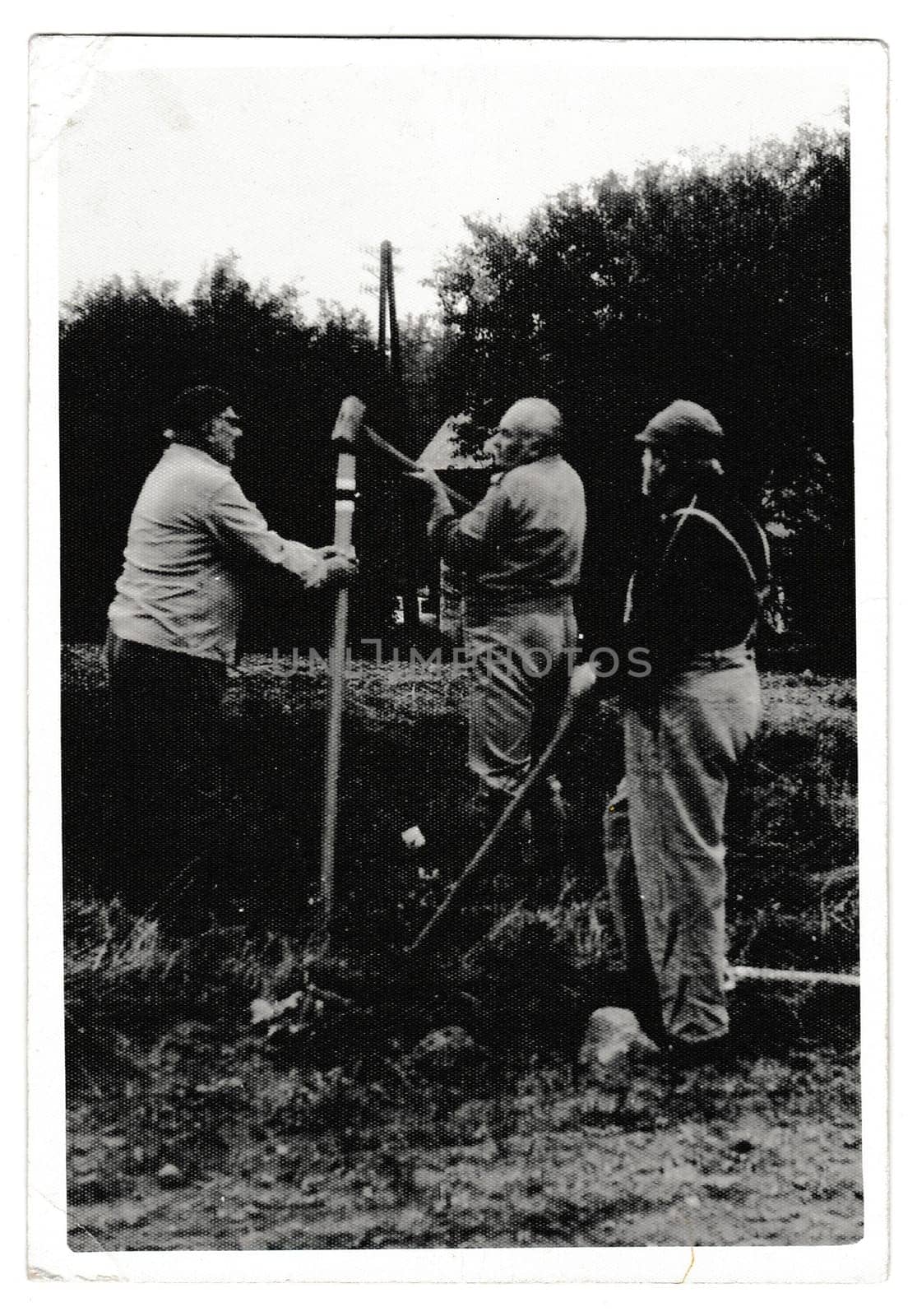 Retro photo shows volunteers build a touristic sign. Black and white vintage photography by roman_nerud