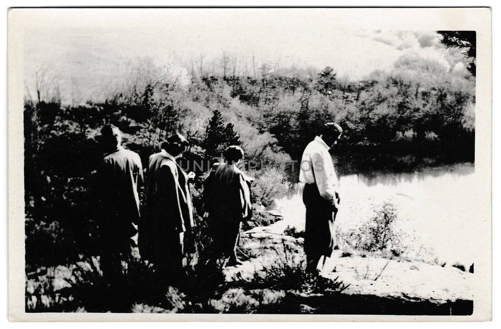 THE CZECHOSLOVAK SOCIALIST REPUBLIC - MAY 9, 1954: Retro photo shows tourists stand on the bank of the pond. Black and white vintage photography