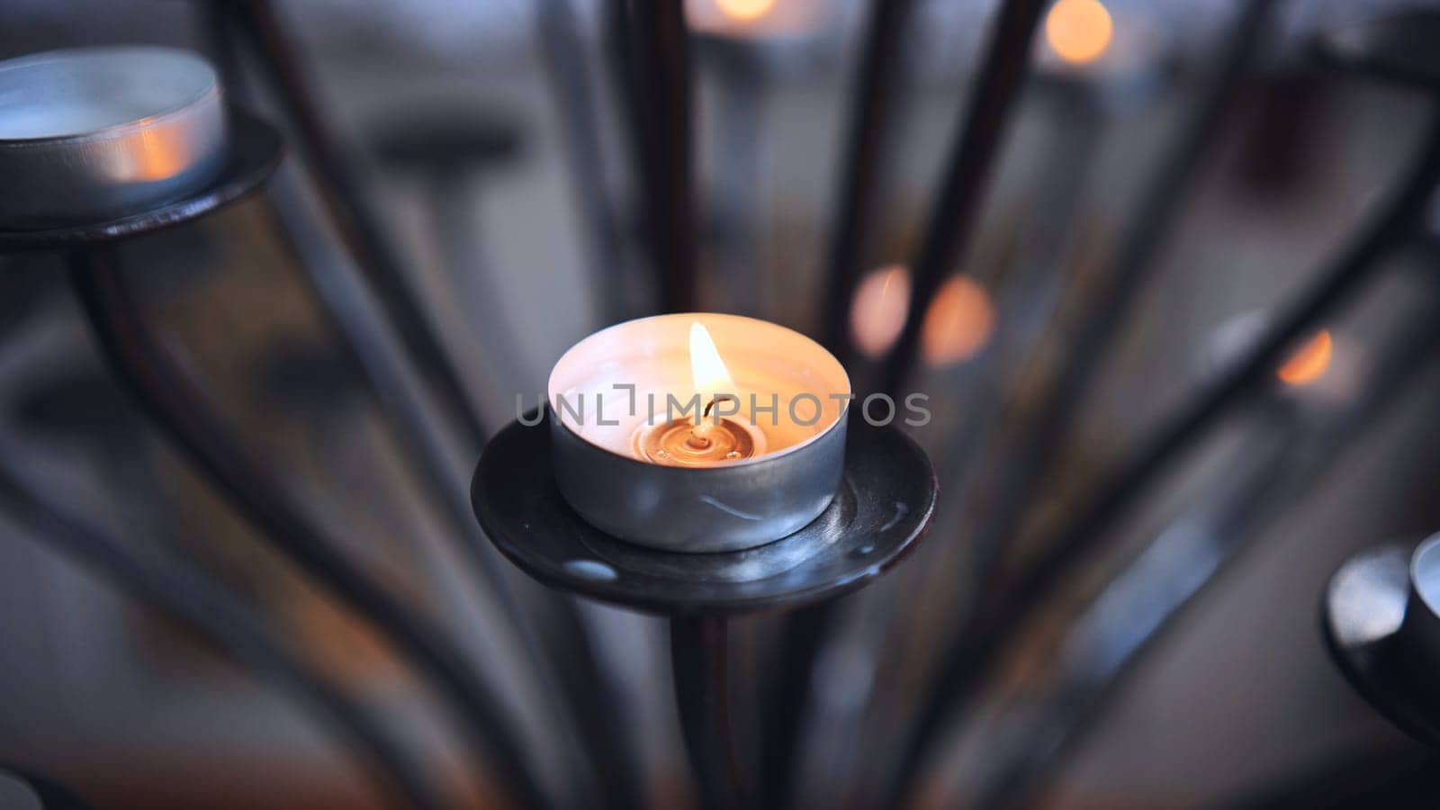 Candlestick holder with burning candles in a Catholic church