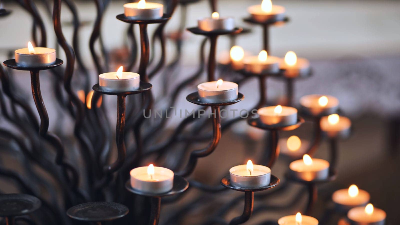 Candlestick holder with burning candles in a Catholic church