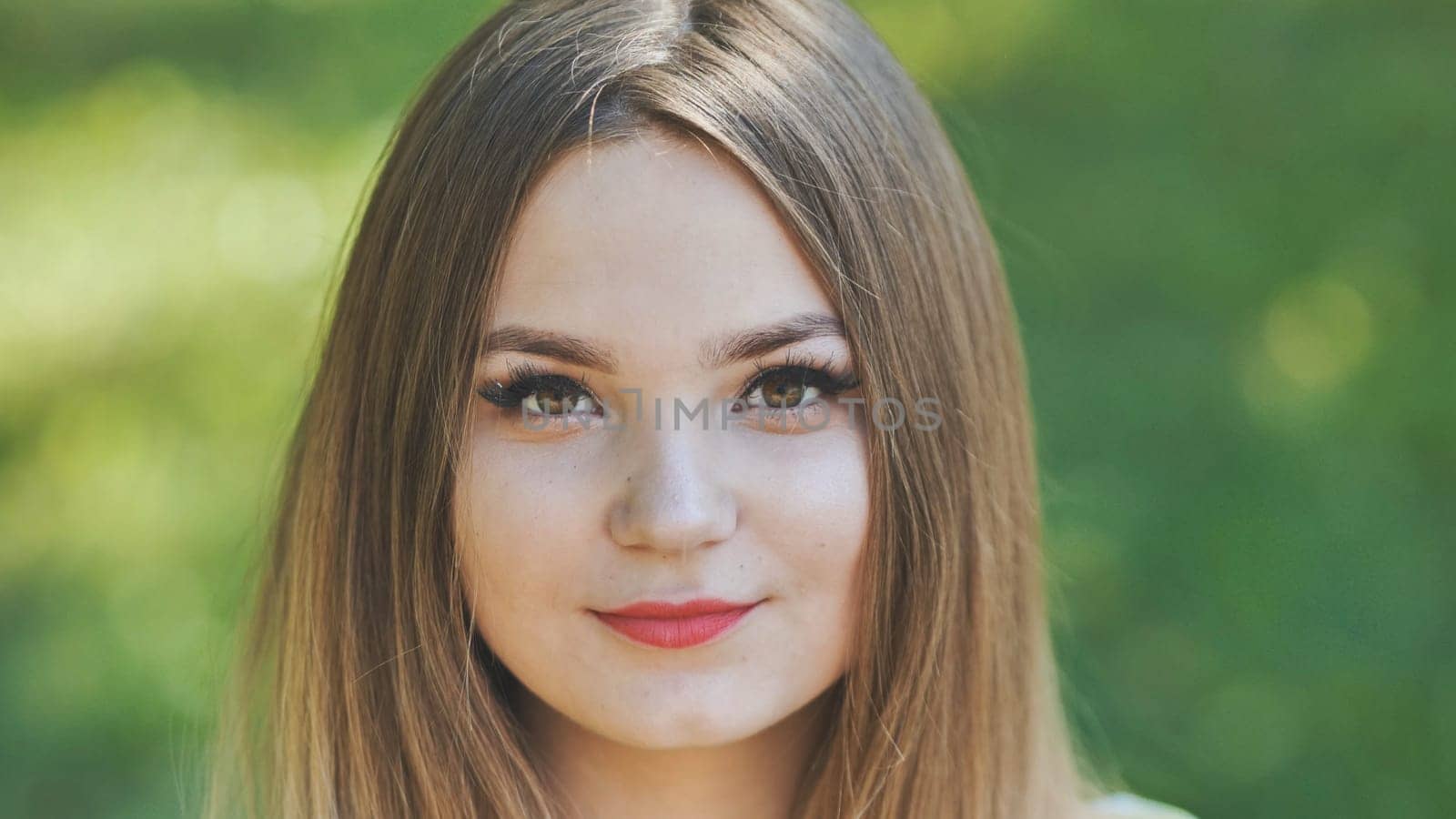 Portrait of a young girl in a park. Close-up of her face