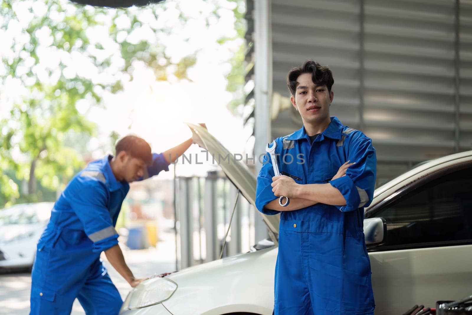 portrait of positive asian auto mechanic in uniform posing after work, he is keen on repairing cars, automobiles by nateemee
