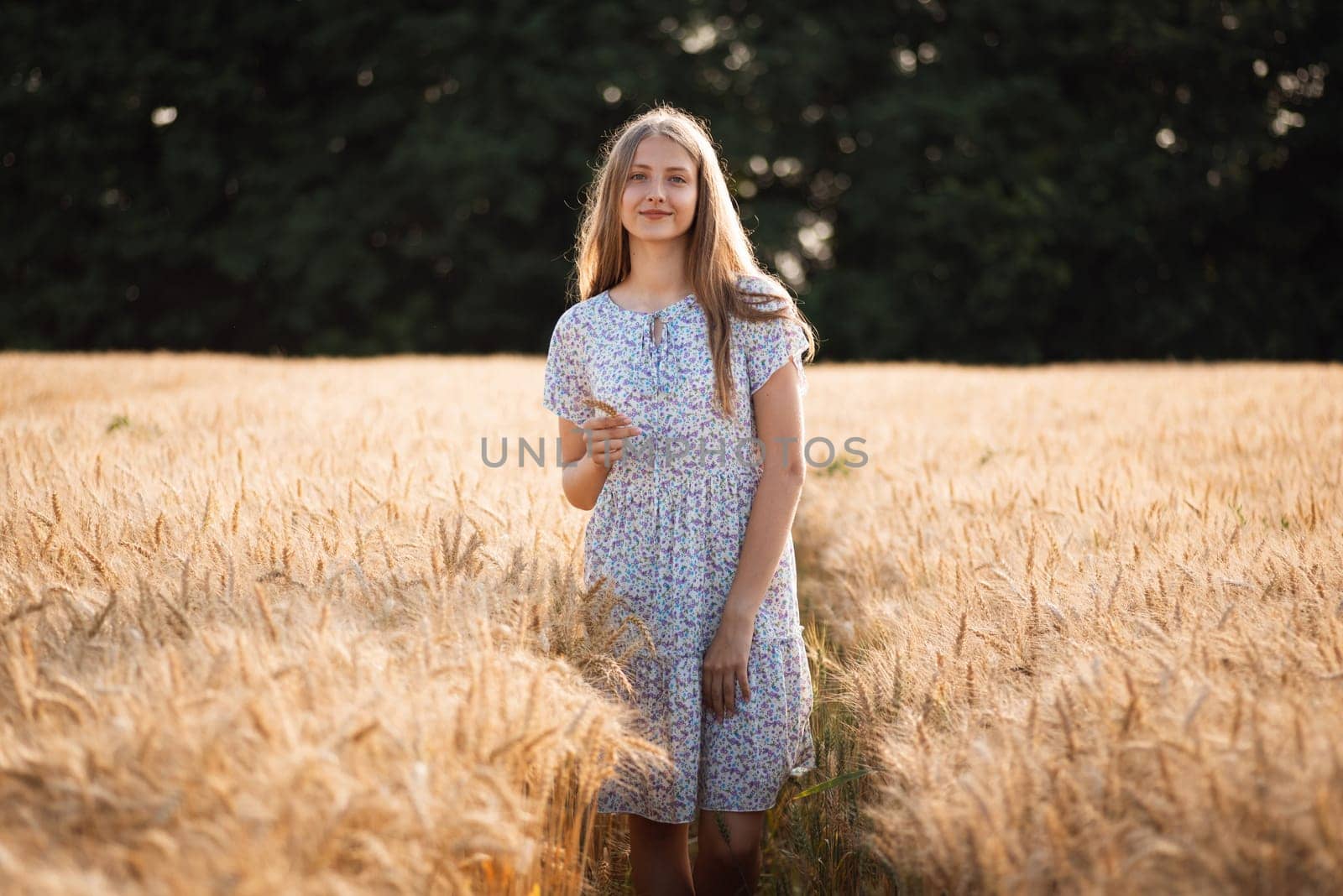 Beautiful girl walking in the field of ripe rye