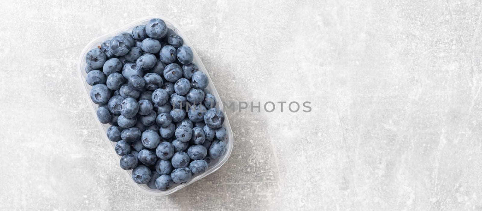 Fresh blueberries in a container on a white background