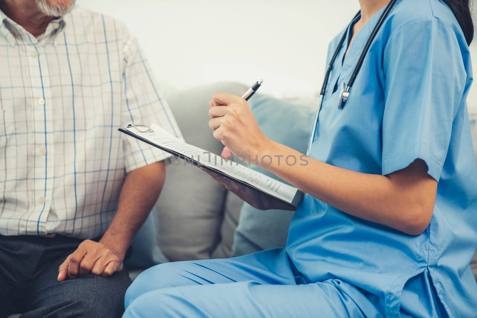 A young female doctor inquires about personal information of a contented senior at home. Medical care for the elderly, elderly illness, and nursing homes, home care.