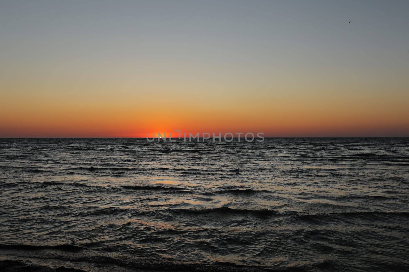 golden sunset or sunrise at the deep dark ocean. aerial view of sundown and up to the sea. yellow and orange colorful sky. romantic beautiful sky in the spring season