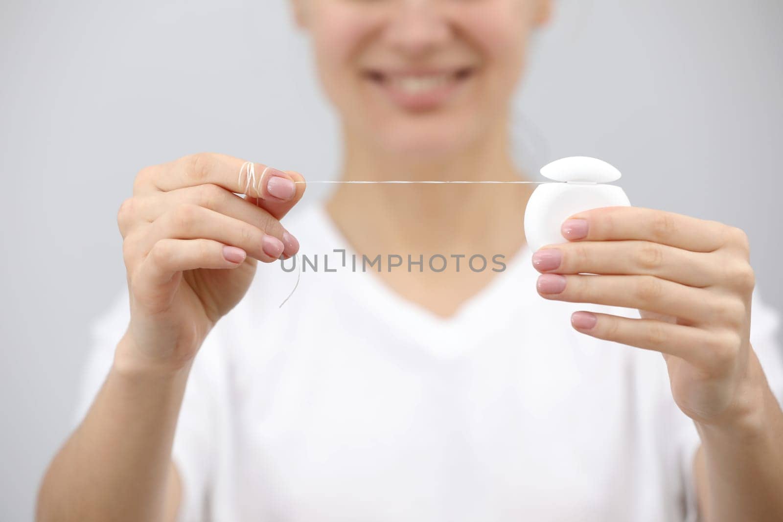 Dental hygiene and care. Dental floss. Young healthy woman face with beauty smile. Beautiful girl. Person healthcare. by Andriimedvediuk
